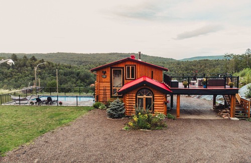 Mandeville Cabin | Charming log cabin nestled in the woods, with a spa and in-ground pool.