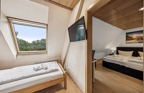 Wilhelmshaven Hotel | Comfortable room with a double and single bed, private bathroom, flat-screen TV, fridge, microwave, coffee machine, and cozy seating area. Ideal for small families or friends traveling together.