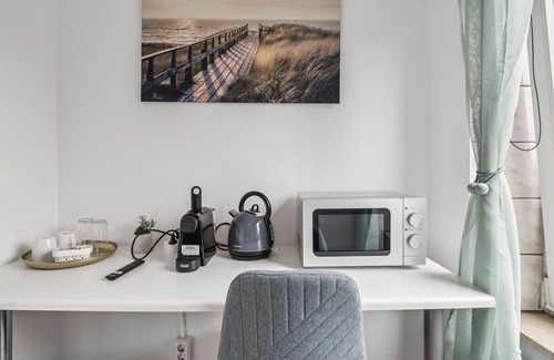 Wilhelmshaven Hotel | Cozy double room, flat-screen TV, and modern bathroom with shower. Ideal for couples and short stays – enjoy a relaxed atmosphere with warm wood accents and coastal charm.