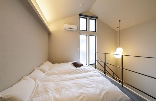 Teradomari Apartment | Earthen dining room with projector