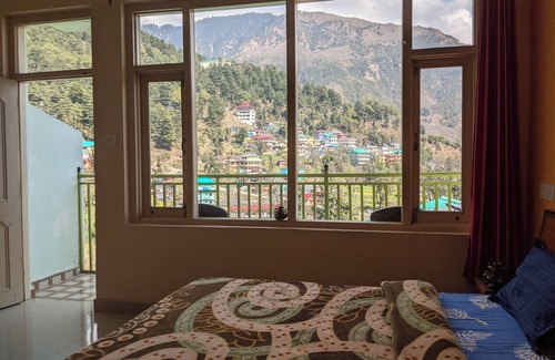 Dharamshala Bed & Breakfast | Golden View BnB Mcleodganj nRoom with private balcony facing mountain view.