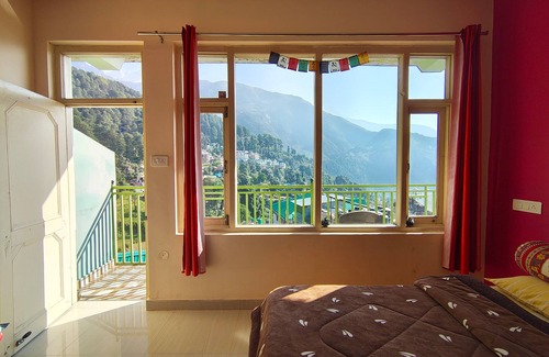 Dharamshala Bed & Breakfast | Golden View BnB Mcleodganj nRoom with private balcony facing mountain view.