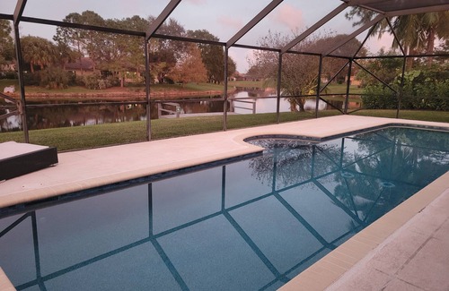 Wellington House | Golf cart distance to WEF! Charming 3 bedroom waterfront home with heated pool.