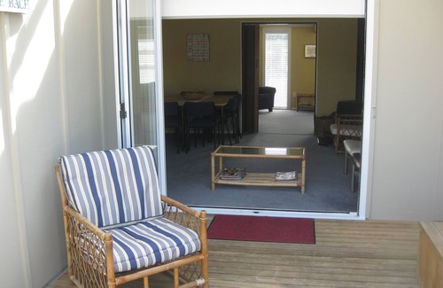 Waitarere Beach House | HAPPY HAVEN has Kiwi Bach character with location.