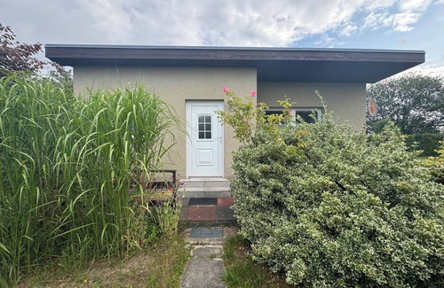 Stuthof House | Idyllic bungalow surrounded by greenery, perfect for relaxing.
