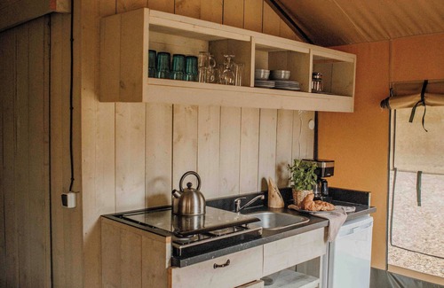 Lieren House | Luxury glamping in the Veluwe: Safaritent for 6 guests with private bathroom, full kitchen, made-up beds & playground view veranda.