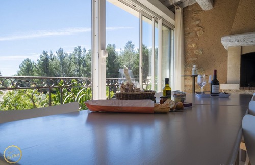 Paradou House | Mas Provençal first floor living room with fireplace and veranda overlooking Alpilles- Vallée des Baux