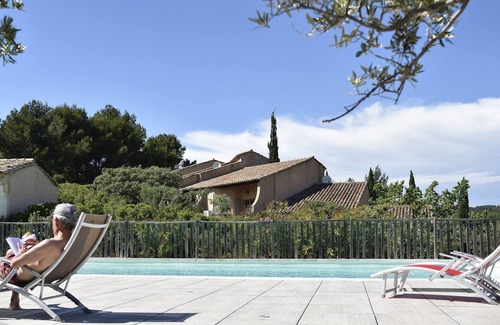 Paradou House | Mas Provençal first floor living room with fireplace and veranda overlooking Alpilles- Vallée des Baux