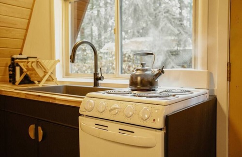 Cle Elum Cabin | Moonshine Digs is the retro A-Frame of your dreams! Hot tub, record player, games, TVs and peace and quiet all nestled in the heart of the Cascade Mountains with Lake Cle Elum access.