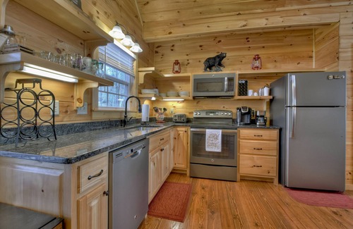 Ellijay Cabin | Mountain Livin' beckons with pet-friendly charm, complete with a fenced yard, soothing hot tub, crackling firepit, and reliable WiFi