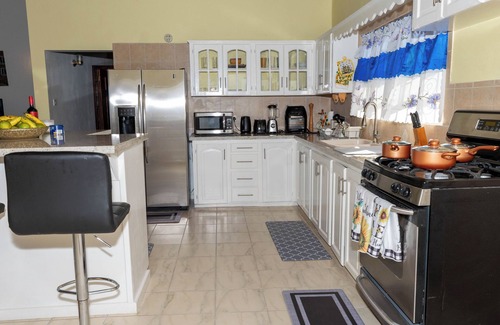 Red Gate House | Open-concept living space cascaded in palm and fruit trees.nFamily-friendly!