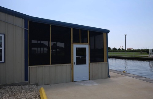 Sabine Pass Cottage | Park your boat in front of the Fishermen's Cottage! Screened in patio.