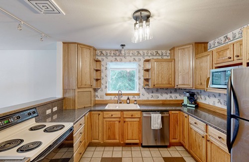 Sandpoint Cabin | Riverfront home with mountain view, hot tub, deck, WiFi, W/D, & fireplace