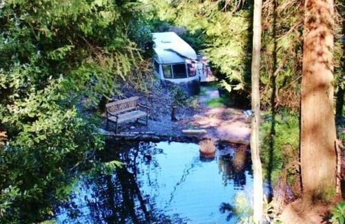 Llanidloes House | Secluded Caravan next to 2 pools & waterfalls. Decking area & Summer house
