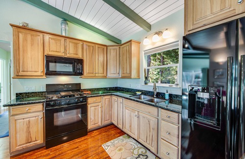 Gualala House | Serene guest suite with shared hot tub, forest views, & splashes of color