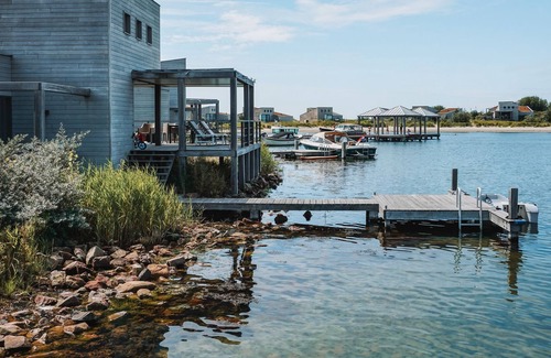 Ouddorp Cabin | Spacious beach villa with private swimming jetty and a terrace on the water.