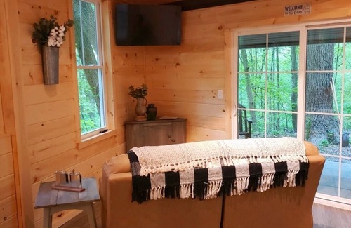 Darlington House | The Chalet is located in the woods of a gated property with a covered porch.