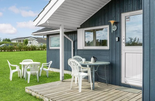 Havnsø House | The cottage has an inviting kitchen-living room with a fireplace and a partially covered terrace.