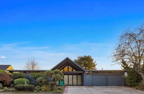 Oak Hills House | This Robert Rummer masterpiece celebrates mid-century design and A. Quincy Jones’ iconic “double gable.” Soak in natural light from the atrium, relax under vaulted ceilings, and retreat to your private hot tub where style and serenity meet.