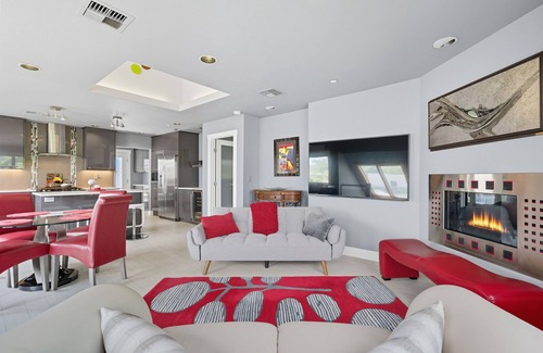 Hough Apartment | Top-level duplex featuring a sleek open concept kitchen with stainless appliances, cozy fireplace, stylish furnishings, and in-unit washer/dryer. Designed for basking in the sun under skylights in thoughtful details throughout.