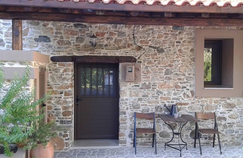 Asklipiio House | Traditional stone built single room house with traditional bed.
