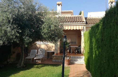 El Algar Villa | View of the sea and the private garden with palm trees and an olive tree.