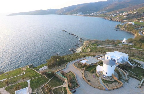 Tinos House | Windmill and houses by the sea / Stavros Bay
