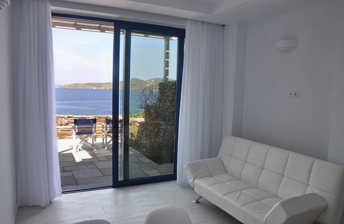 Tinos House | Windmill and houses by the sea / Stavros Bay