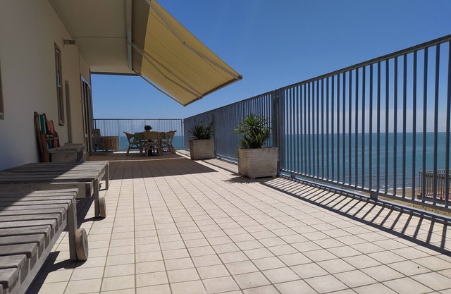 Apartment with large terrace right by the sea