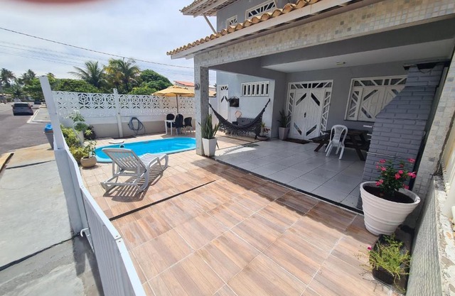 Casa cinza em frente à praia em condominio