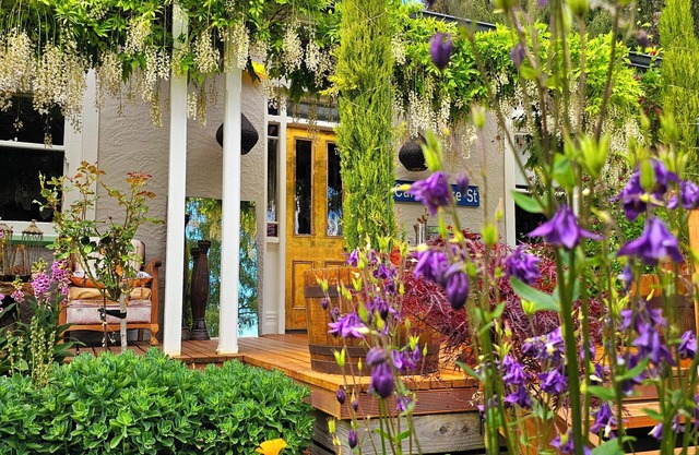 Cozy, beautifully decorated cottage sitting in a stunning seasonal garden