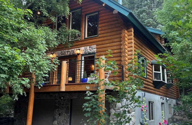 Cozy log cabin secluded in a mountain forest with hot tub, sauna, private patio.