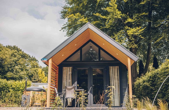 Experience luxury and nature in the Tiny Lodge in the Veluwe! Single-story with 2 bedrooms, a fully equipped kitchen, air conditioning, and a private hot tub in the garden.