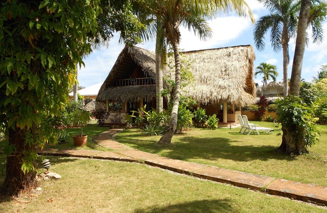 Palm-covered house in the tropical garden