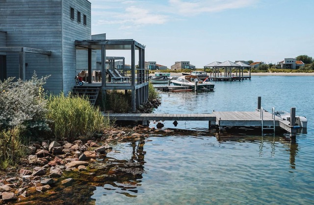Spacious beach villa with private swimming jetty and a terrace on the water.