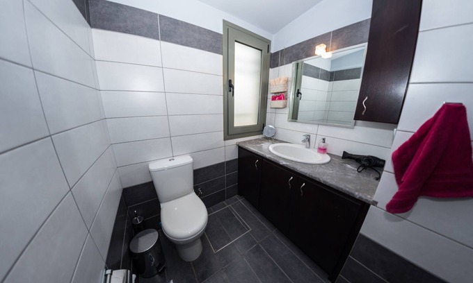 Porto Heli Cottage | A detached house which is embraced by green trees and beautiful flowers.