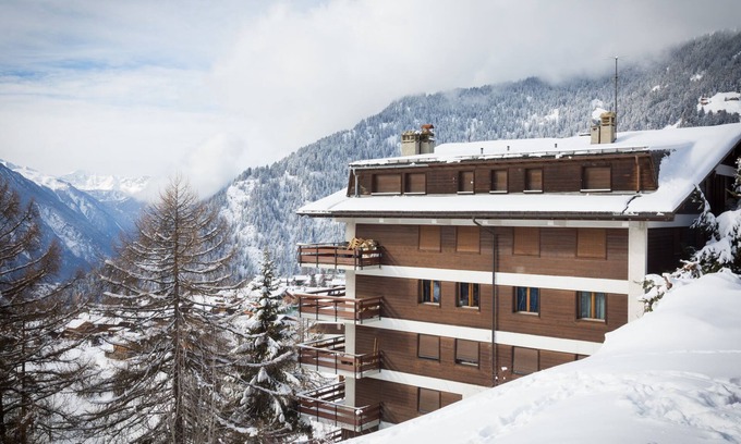 Verbier Apartment | A large entrance hall, living room with dining area and fireplace, kitchen with dishwasher, oven and