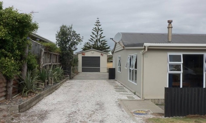 Waitarere Beach House | HAPPY HAVEN has Kiwi Bach character with location.