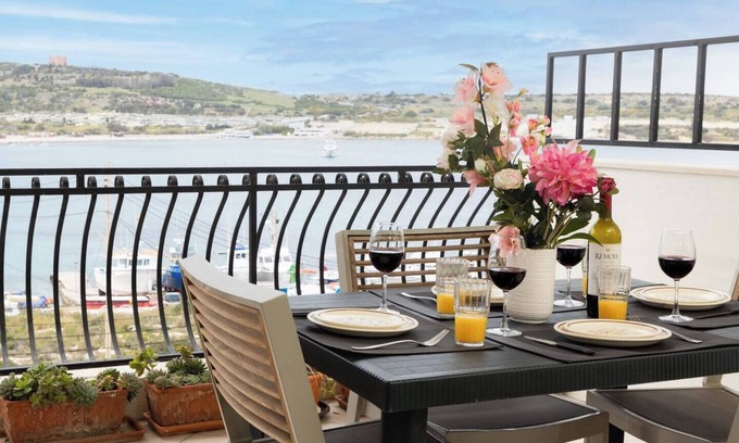 Għadira Apartment | Seafront apartment just steps from Mellieħa Bay, with stunning views of the bay and Red Tower. Enjoy spectacular sunsets, walk to nearby restaurants and amenities, and catch the bus right outside.