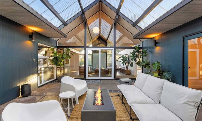 Oak Hills House | This Robert Rummer masterpiece celebrates mid-century design and A. Quincy Jones’ iconic “double gable.” Soak in natural light from the atrium, relax under vaulted ceilings, and retreat to your private hot tub where style and serenity meet.