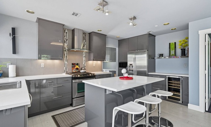 Hough Apartment | Top-level duplex featuring a sleek open concept kitchen with stainless appliances, cozy fireplace, stylish furnishings, and in-unit washer/dryer. Designed for basking in the sun under skylights in thoughtful details throughout.