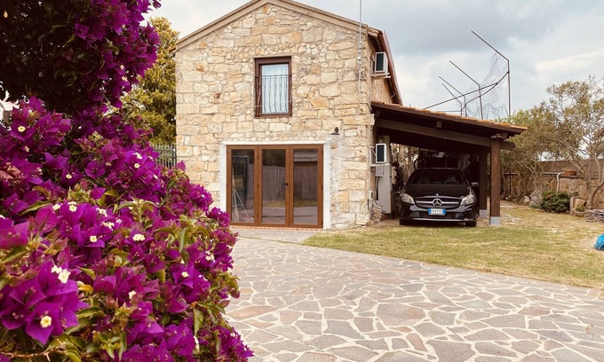 San Giovanni Suergiu Villa | Villa with garden, large windows, exposed beams and stones