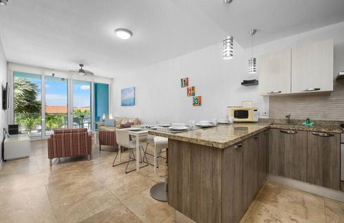 Boegoeroei Condo | Gated community with resort-style amenities - 2 bedroom, 2 bath with an open concept living room and kitchen. Private balcony overlooks pool area.