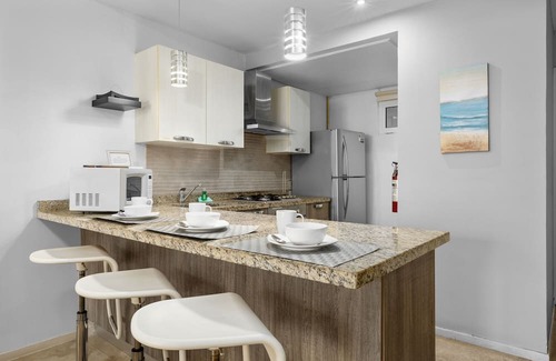 Boegoeroei Condo | Gated community with resort-style amenities - 2 bedroom, 2 bath with an open concept living room and kitchen. Private balcony overlooks pool area.