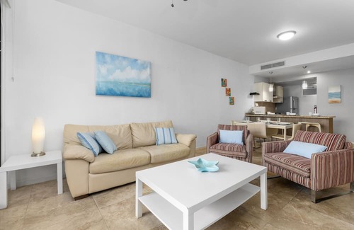 Boegoeroei Condo | Gated community with resort-style amenities - 2 bedroom, 2 bath with an open concept living room and kitchen. Private balcony overlooks pool area.